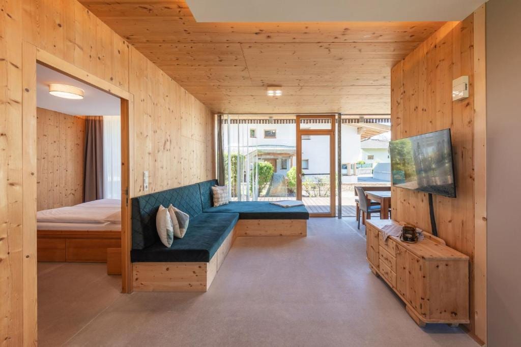 Wohnzimmer mit Sofa, TV und Zugang zur Terrasse